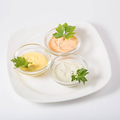Three different sauces on a white background