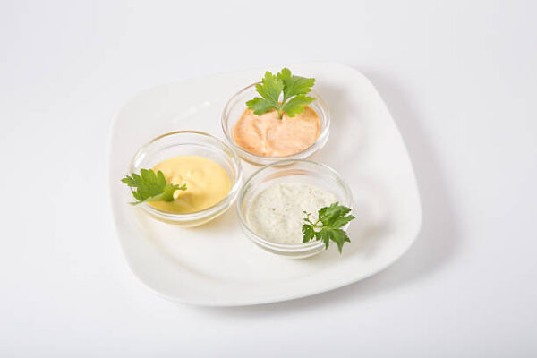 Three different sauces on a white background